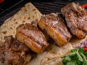 Shish kebabs grilling over charcoal at Shashlik House NYC
